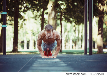 Athlete doing exercises at stadium at park 43299501