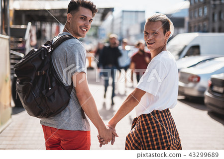 Satisfied man holding arm of friend outside Satisfied man holding arm of friend outside 43299689