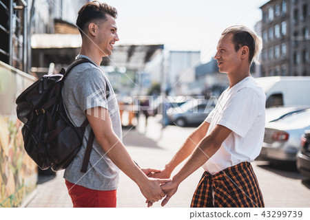 Cheerful men going along city during day 43299739