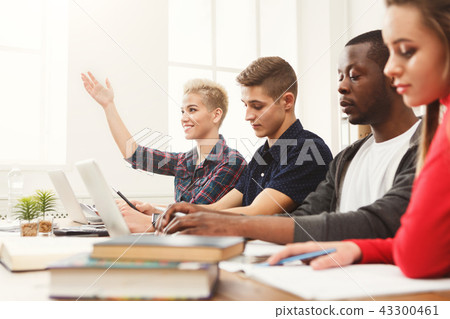 Group of diverse students studying at wooden table 43300461
