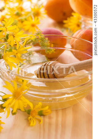 Honey stick and a glass jar 43300572