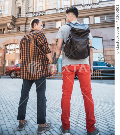 Serious travelers speaking during walk at street 43300801