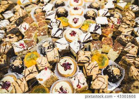 Delicious and tasty dessert table with cupcakes shots at reception closeup 43301608