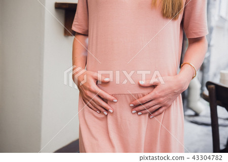 Young woman's holding hands on belly Young woman's holding hands on belly 43304782