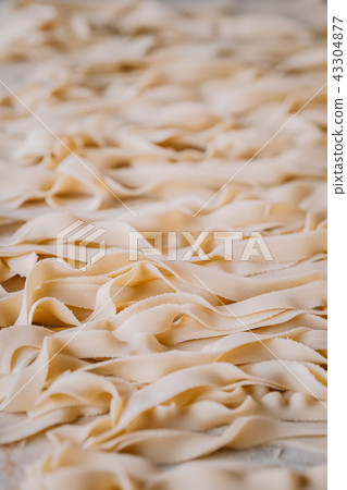 Raw Italian tagliatelle pasta background 43304877