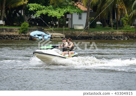 Happy young couple having fun riding on a jet ski 43304915