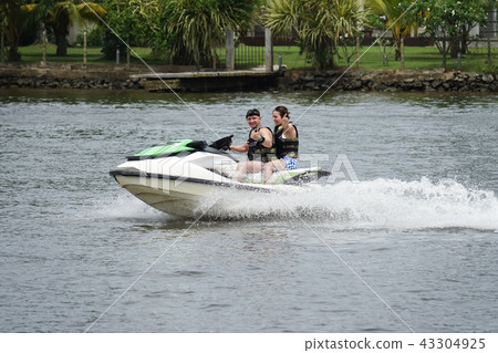Happy young couple having fun riding on a jet ski 43304925