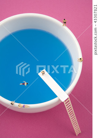 Miniature people in a mug pool 43307821