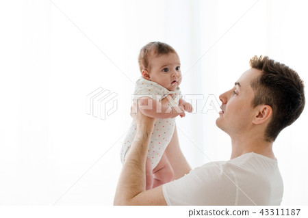 Man holding newborn on white background Man holding newborn on white background 43311187