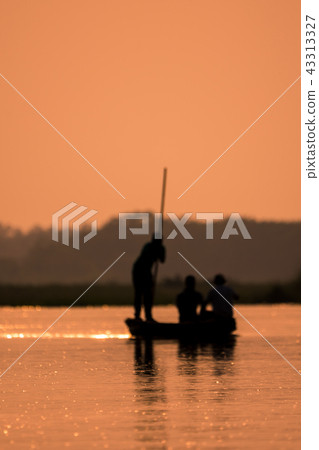 Blurred Men in a boat on a river silhouette Blurred Men in a boat on a river silhouette 43313327