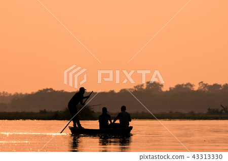Men in a boat on a river silhouette Men in a boat on a river silhouette 43313330