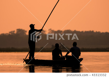 Men in a boat on a river silhouette 43313332