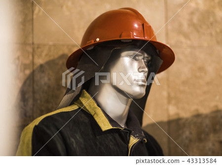 Exhibition firefighter dummy in fire fighter helmet and uniform. Protective rescue wear. Head light 43313584