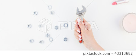 Female hand holding spanner on white background Female hand holding spanner on white background 43313692