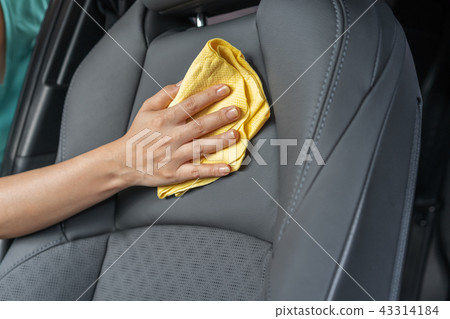hand with microfiber cloth cleaning leather seat 43314184