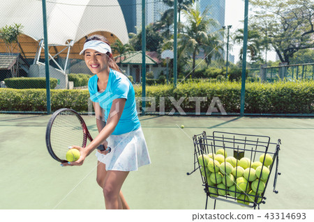 Cheerful beautiful woman playing tennis in a developed city 43314693