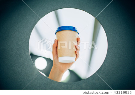 Hands with manicure and cup of coffee to go 43319935