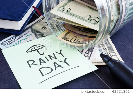 Rainy day fund savings. Jar with dollar bills. 43321501