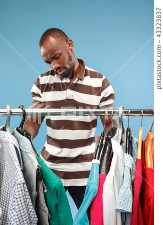 Handsome man with beard choosing shirt in a shop 43323837