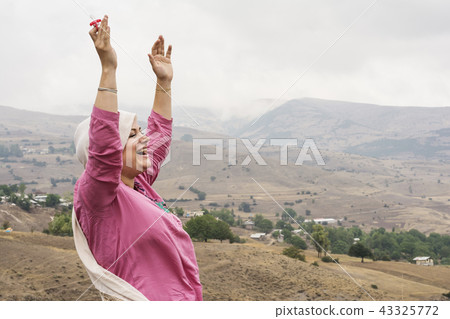 Happy Muslim woman with dummy at hand in outdoor a Happy Muslim woman with dummy at hand in outdoor a 43325772