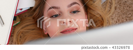 young beautiful woman lie on floor have a lot of work hold tablet in arms 43326978