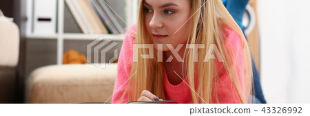 young beautiful blond woman lie on the floor read book 43326992