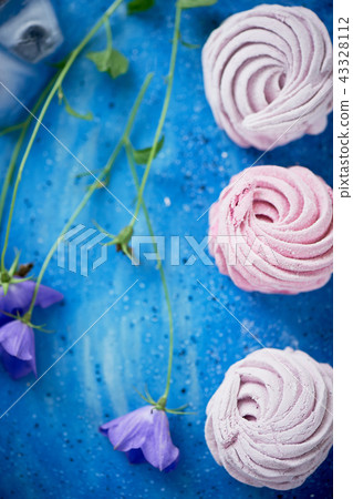 The marshmallow on a blue sky plate. Light dessert.Delicate wildflowers. And frozen in the ice The marshmallow on a blue sky plate. Light dessert.Delicate wildflowers. And frozen in the ice 43328112