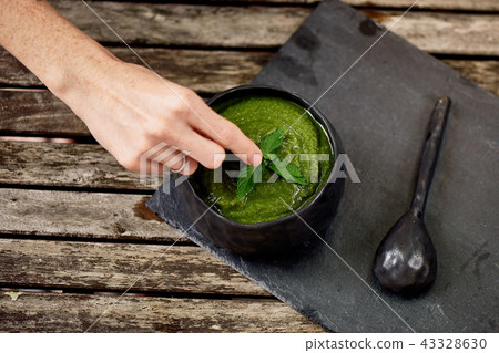 Women's hand adorns the soup puree of green vegetables.Vegetarian simple food 43328630