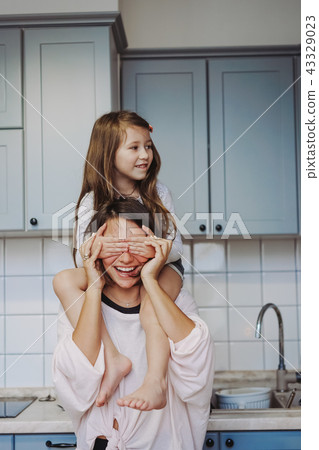 beautiful little daughter piggybacking on her happy mother 43329023