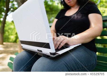 obese female worker with laptop working outdoors obese female worker with laptop working outdoors 43329705