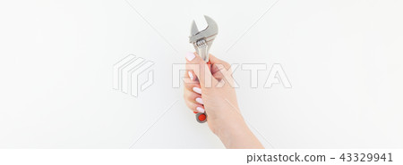 Female hand holding spanner on white background Female hand holding spanner on white background 43329941