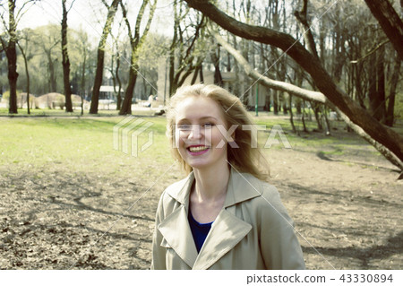 happy blrunette young woman in green spring park smiling, lifest 43330894