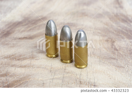 The 9mm caliber cartridge on wooden background 43332323