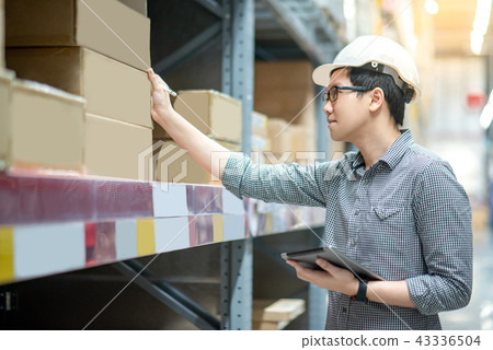 Asian man doing stocktaking on tablet in warehouse Asian man doing stocktaking on tablet in warehouse 43336504