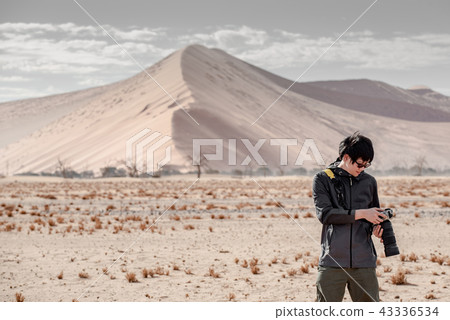 Male photographer taking photo in Namib desert 43336534