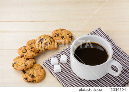 Cup of coffee with cookie on wood table. 43336804