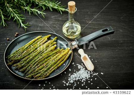 asparagus in a pan on a wooden black table with rosemary salt and olive oil asparagus in a pan on a wooden black table with rosemary salt and olive oil 43339622