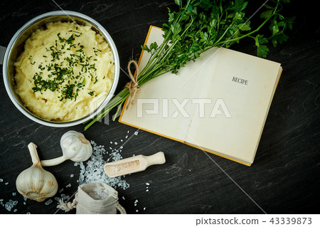 silver pot with delicious pure next to a recipe book on a black table 43339873