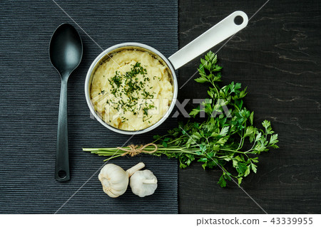 creamy puree of potatoes sprinkled with parsley in a silver pot on a black table creamy puree of potatoes sprinkled with parsley in a silver pot on a black table 43339955