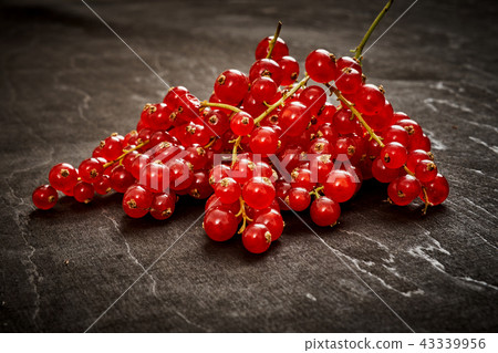 juicy red currant on an old black wooden table 43339956