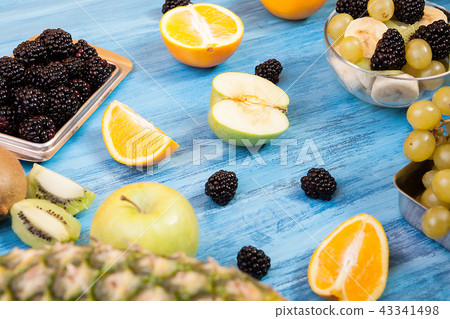 Different fruits and berries on wooden blue table Different fruits and berries on wooden blue table 43341498