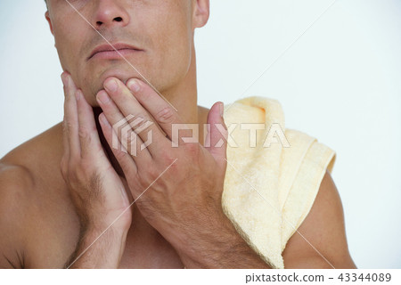 Man touching face after shaving Man touching face after shaving 43344089