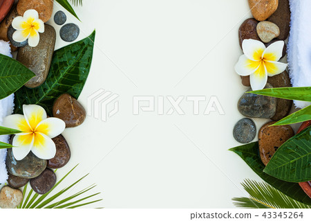 Green leaves, white tropical flowers and stones 43345264