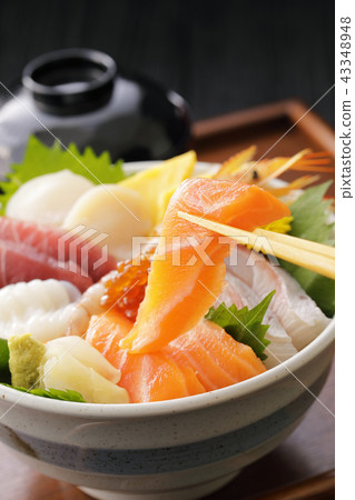 Bowl of rice topped with sashimi  43348948