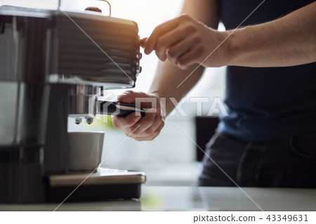 A man prepares espresso for a coffee maker 43349631