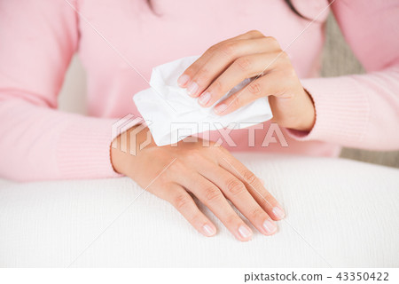 Woman cleaning her hands with a tissue. Woman cleaning her hands with a tissue. 43350422