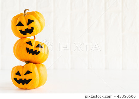 Stack of yellow ghost pumpkin on white brick block Stack of yellow ghost pumpkin on white brick block 43350506
