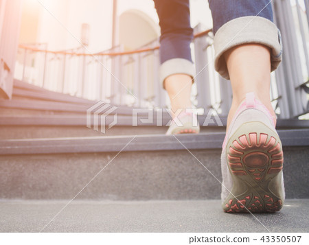 Young adult woman walking up the stairs Young adult woman walking up the stairs 43350507