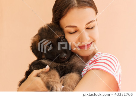 Beautiful girl hugging tight her cute small puppy 43351766