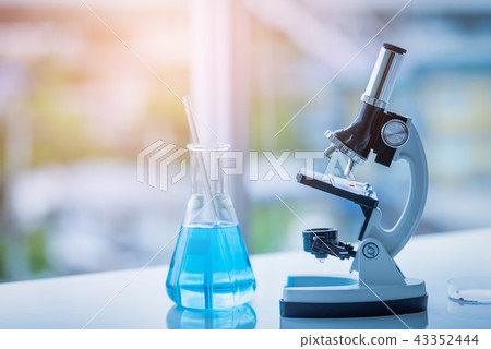 Microscope and Beaker on table in Laboratory. 43352444